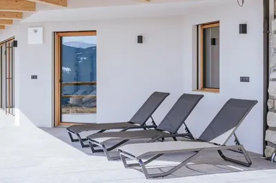 four chairs lined up in a room with a window at Chalets Hansleitner in Terento