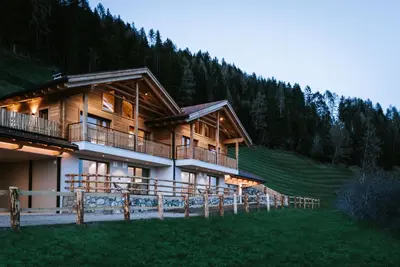 a large wooden building in the middle of a mountain at Chalets Hansleitner in Terento