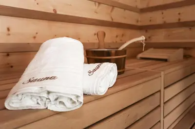 a sauna with towels and a sink in it at Hotel Gasthof Höllriegl in Sarntal