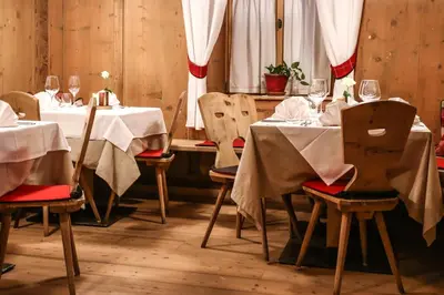 a dining room with tables and chairs with wine glasses at Hotel Gasthof Höllriegl in Sarntal