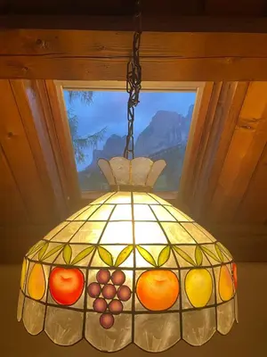 a stained glass chandelier hanging in front of a window at Splendida Carezza in Carezza al Lago