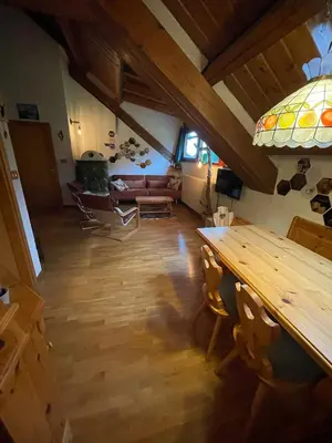 a living room with a table and a couch at Splendida Carezza in Carezza al Lago