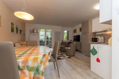 a kitchen and a living room with a table and chairs at Casa Baranci in Pozza di Fassa