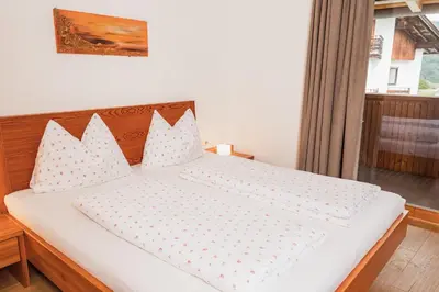a bedroom with a large white bed with pillows at Huberhof in Naz-Sciaves