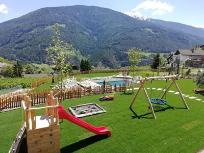 a playground with a slide and a swing at Huberhof in Naz-Sciaves