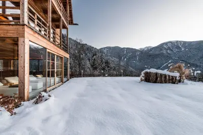 a snow covered roof of a house with mountains in the background at Alma Apartments in Luson