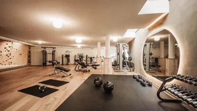 a gym with several exercise equipment in a room at Alma Apartments in Luson