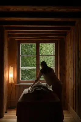 a woman sitting on a bed in front of a window at Alma Apartments in Luson
