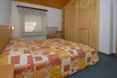 a bedroom with a large bed in a room at CASA PINUCCIA MANSARDA in Predazzo