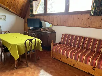 a living room with a table and a couch at CASA PINUCCIA MANSARDA in Predazzo
