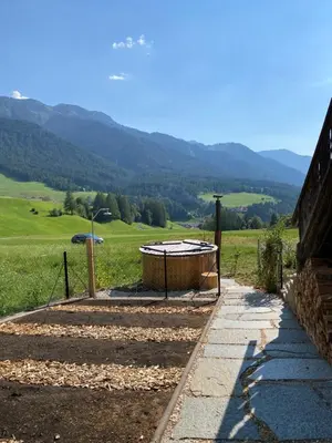 a hot tub in the middle of a field at Farmhouse with a stunning view over the dolomites in Villnoss