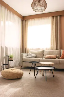 a living room with a couch and tables in front of a window at haus e Apartment 1 in Lana