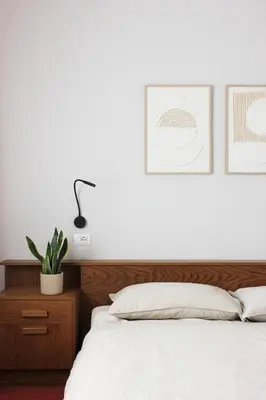 a bedroom with a white bed with a wooden headboard at haus e Apartment 1 in Lana