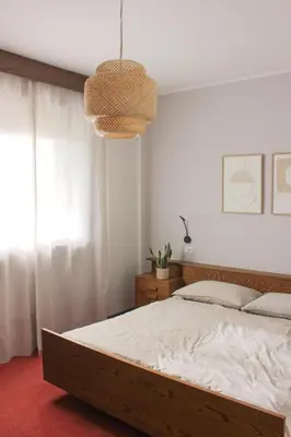a bedroom with a large bed and a chandelier at haus e Apartment 1 in Lana