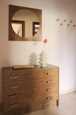 a dresser with a vase on it with a mirror at haus e Apartment 1 in Lana
