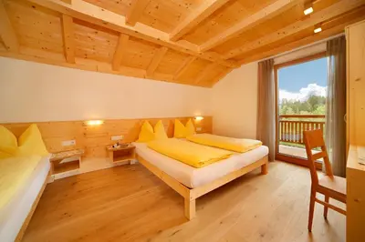 a bedroom with two beds and a large window at Beimsteinhof in Verano