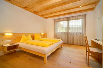 a bedroom with a bed with yellow pillows and a window at Beimsteinhof in Verano