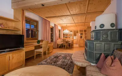 a living room with a stove and a dining room at Lusina Apartments in Luson