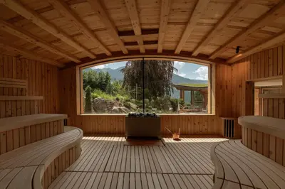 an inside view of a wooden room with a large window at Lusina Apartments in Luson