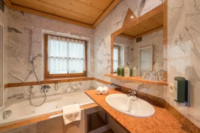 a bathroom with a tub and a sink and a bath tub at Lusina Apartments in Luson