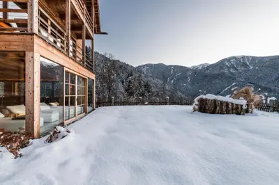 a snow covered yard with mountains in the background at Lusina Apartments in Luson