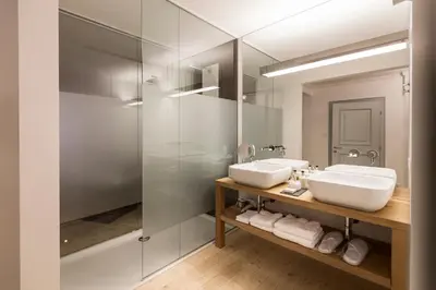 a bathroom with two sinks and a glass shower at Gius La Diffusa in Caldaro