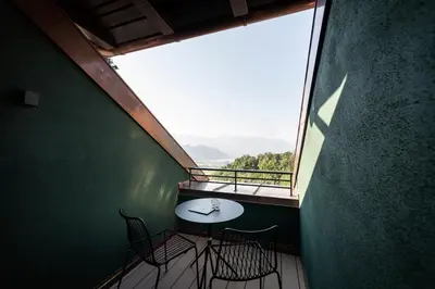 a balcony with a table and chairs and a large window at Gius La Diffusa in Caldaro