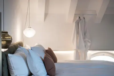 a bedroom with a bed with pillows and a window at Gius La Diffusa in Caldaro