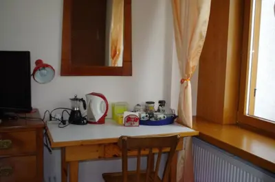 a kitchen counter with a table and a chair on it at ROOM AURORA in Fiera di Primiero