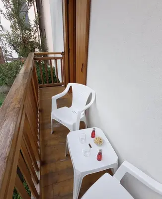 a small white table and chairs on a balcony at ROOM AURORA in Fiera di Primiero