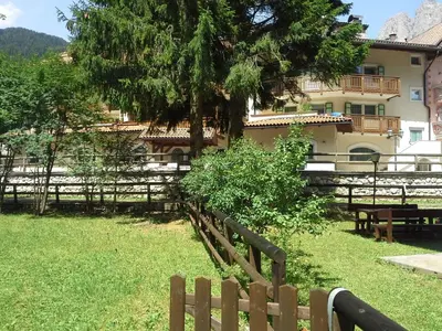a wooden fence in front of a building at Appartamento Niki Campitello in Campitello di Fassa