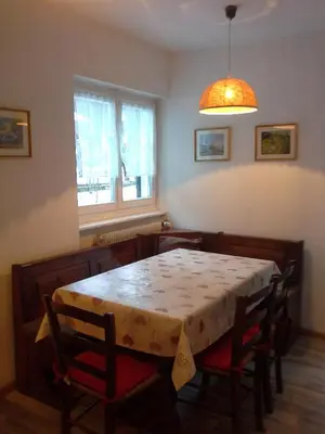a dining room with a table and chairs and a window at Appartamento Niki Campitello in Campitello di Fassa
