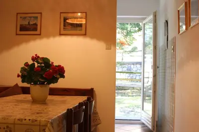 a dining room with a table with a vase of flowers on it at Appartamento Niki Campitello in Campitello di Fassa