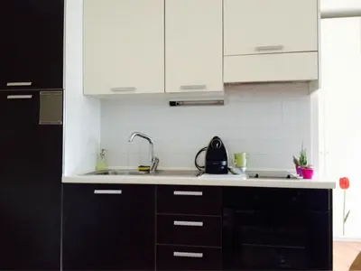 a kitchen with white cabinets and a sink at Loft l'Alessandra in Bolzano