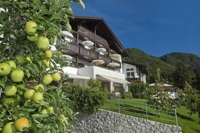 a building with a stone wall in front of it at Pension Riedingerhof in Merano