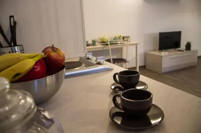 a bowl of fruit and two cups on a kitchen counter at Apartments Fewo in Bolzano