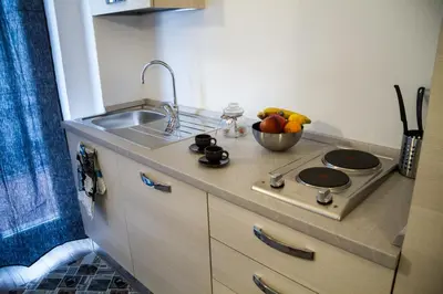 a kitchen with a stove and a bowl of fruit at Apartments Fewo in Bolzano