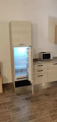 a kitchen with an open refrigerator in a kitchen at Apartments Fewo in Bolzano