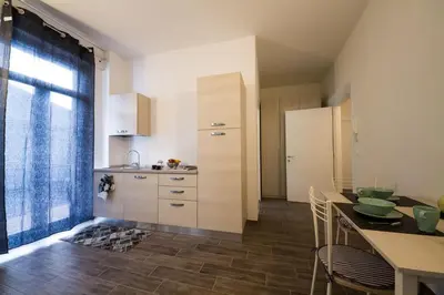 a kitchen with white cabinets and a table with chairs at Apartments Fewo in Bolzano
