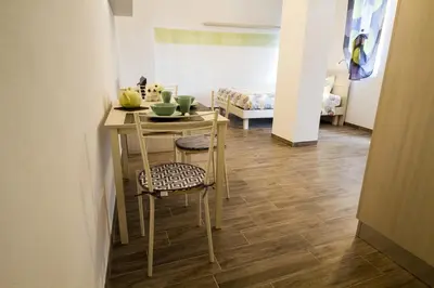 a room with a table and chairs and a bed at Apartments Fewo in Bolzano