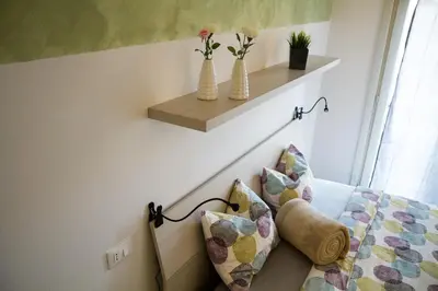 a bedroom with a bed with two vases on the wall at Apartments Fewo in Bolzano