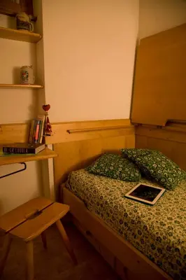 a small bedroom with a bed and a table at I cuori in Cortina dʼAmpezzo