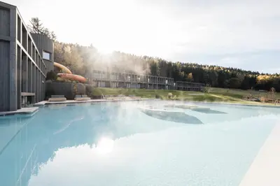 a large swimming pool in front of a building at AKI Family Resort PLOSE in Bressanone