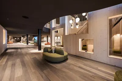 a living room with a green couch on the floor at AKI Family Resort PLOSE in Bressanone