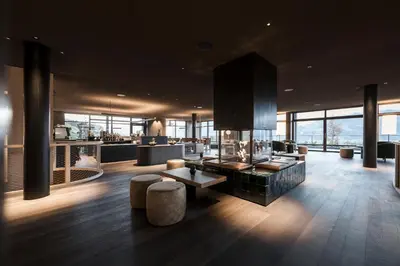 a lobby of a building with a lot of windows at AKI Family Resort PLOSE in Bressanone
