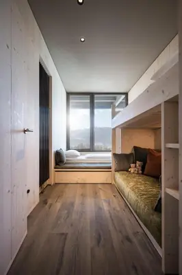 a bedroom with a bunk bed and a window at AKI Family Resort PLOSE in Bressanone