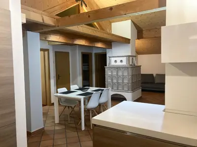 a kitchen with a table and chairs in a room at CASA BAMBA in Tesero