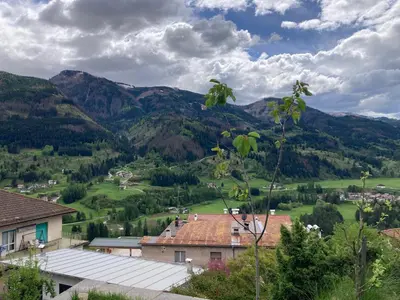 a view of a village with mountains in the background at CASA BAMBA in Tesero