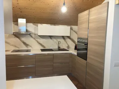 a kitchen with wooden cabinets and a sink at CASA BAMBA in Tesero