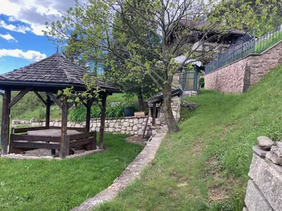 a gazebo with a bench in a yard at CASA BAMBA in Tesero